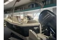 Slide: The Image of 2025 Scout 195 Sport Dorado boat with outboard motor in showroom. - 1