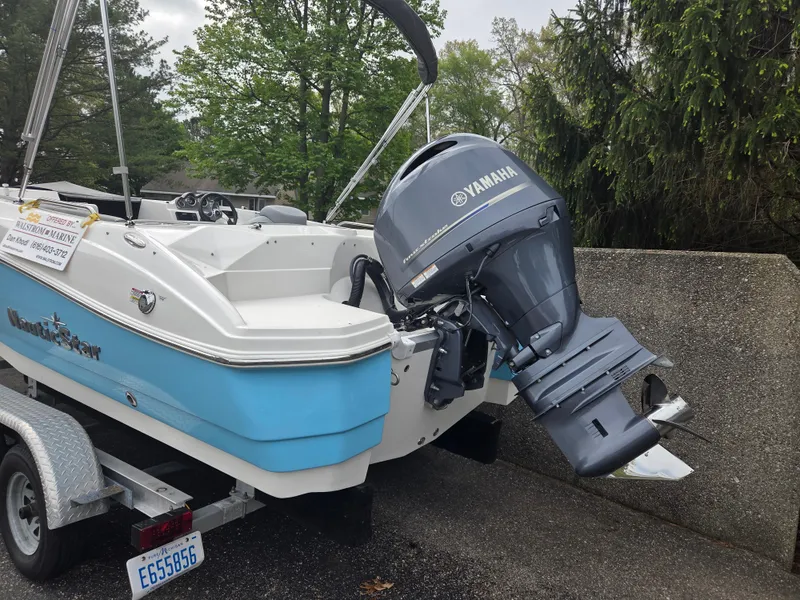 Slide: The Image of 2023 NauticStar 203DC boat with Yamaha outboard motor on a trailer. - 2