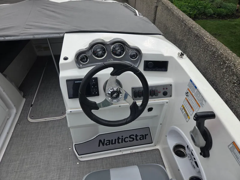 Slide: The Image of 2023 NauticStar 203DC boat dashboard with steering wheel and control panel. - 5