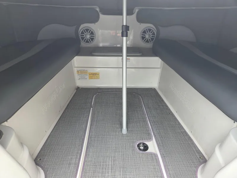 Slide: The Image of 2023 NauticStar 203DC interior cabin with seating and speakers. - 6