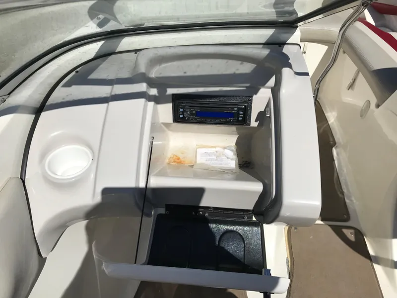 Slide: The Image of 2005 Larson Senza 186 I/O boat dashboard with stereo and storage compartments. - 12