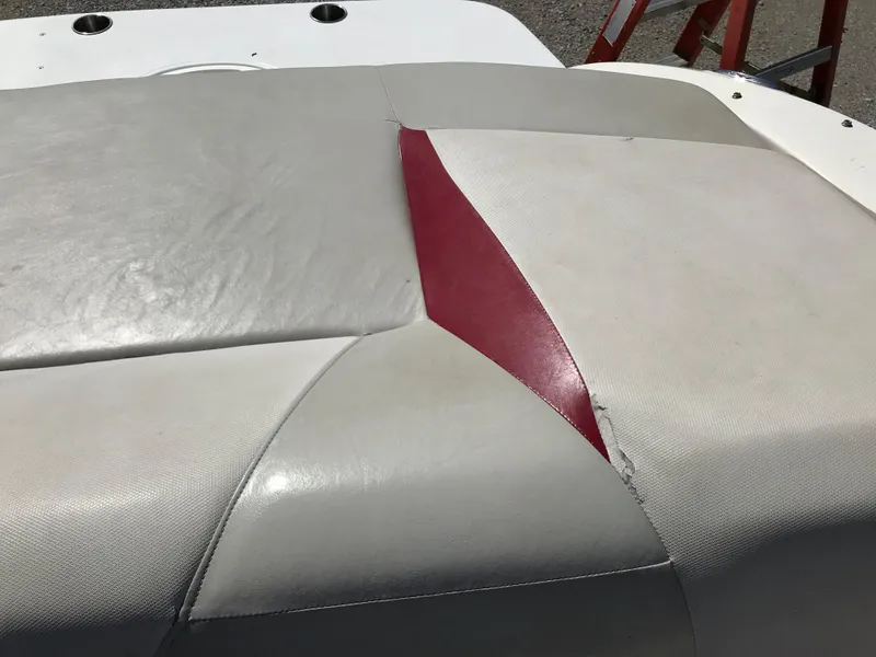 Slide: The Image of 2005 Larson Senza 186 I/O boat seat with red and gray upholstery damage. - 24
