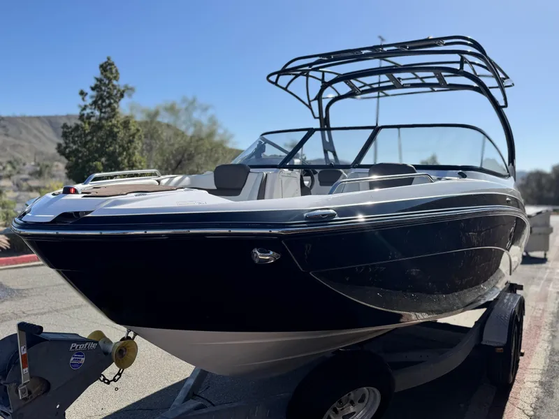 Slide: The Image of 2016 Yamaha Boats 242 Limited E-Series on trailer, sleek black design, outdoor setting. - 3