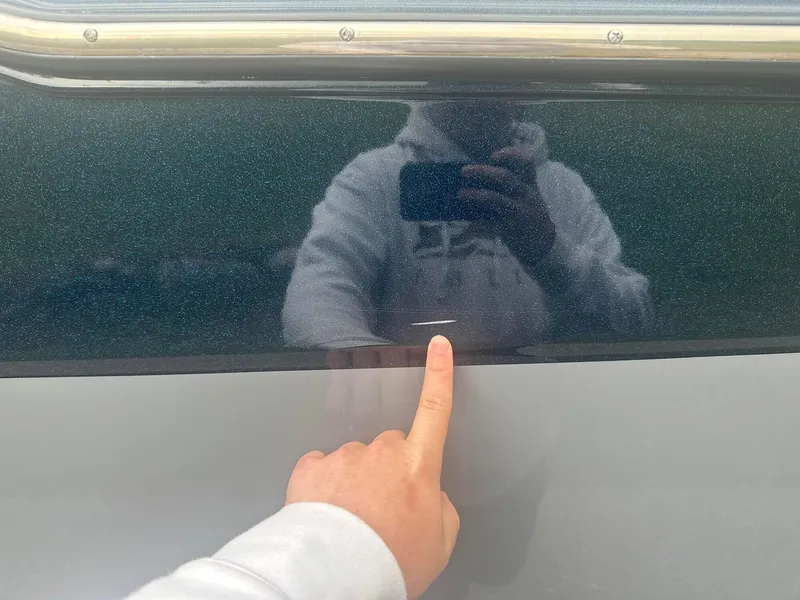 Slide: The Image of Person pointing at scratch on 2022 Malibu M220 boat surface. - 26