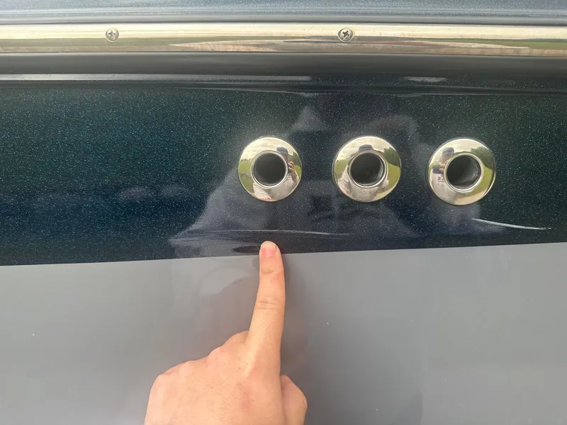 Slide: The Image of Close-up of 2022 Malibu M220 boat with finger pointing at hull detail. - 27