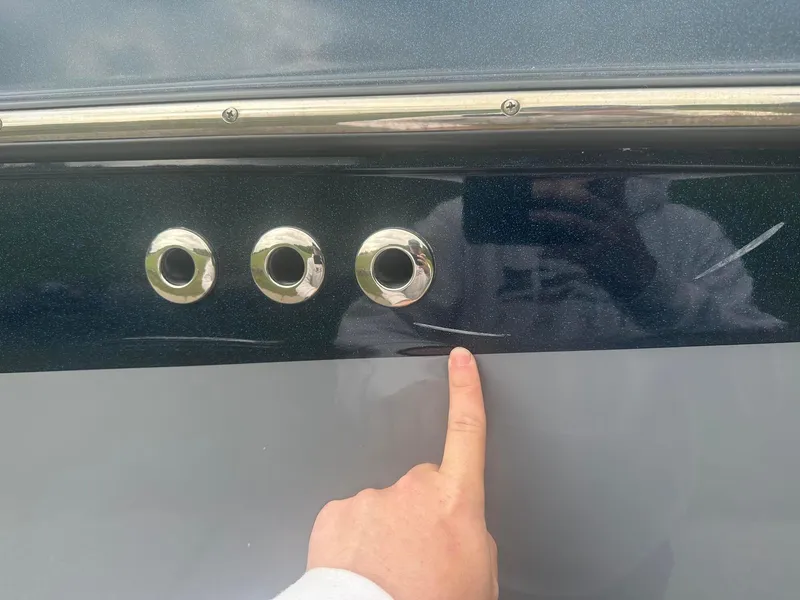 Slide: The Image of 2022 Malibu M220 boat with finger pointing at scratches on the hull. - 28