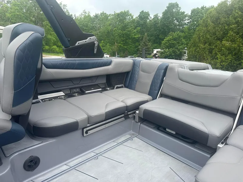 Slide: The Image of 2022 Malibu M220 boat interior with luxurious gray and blue seating. - 32