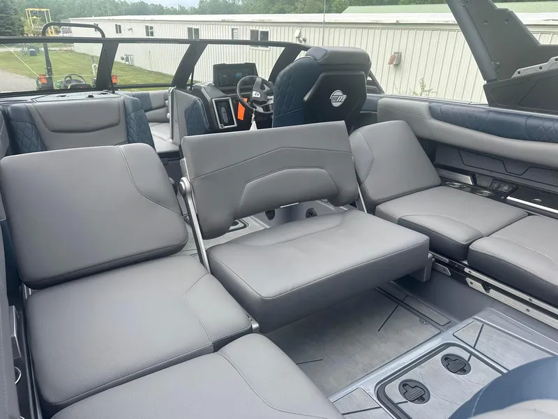 Slide: The Image of 2022 Malibu M220 boat interior with luxurious gray seating and modern dashboard. - 35