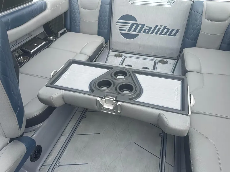 Slide: The Image of 2022 Malibu M220 boat interior with foldable table and cup holders. - 36
