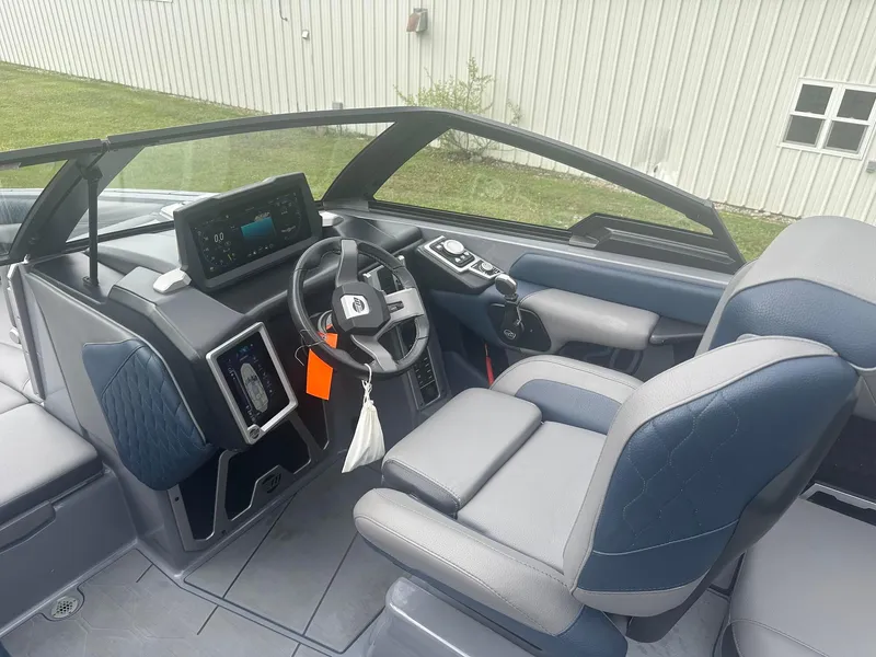 Slide: The Image of 2022 Malibu M220 boat interior with modern dashboard and steering wheel. - 37