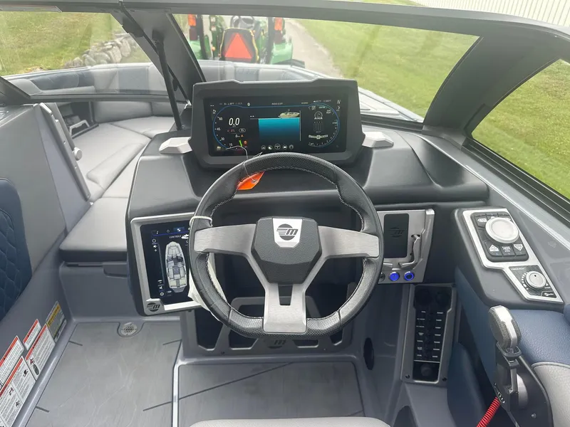 Slide: The Image of 2022 Malibu M220 boat dashboard with steering wheel and digital display. - 6