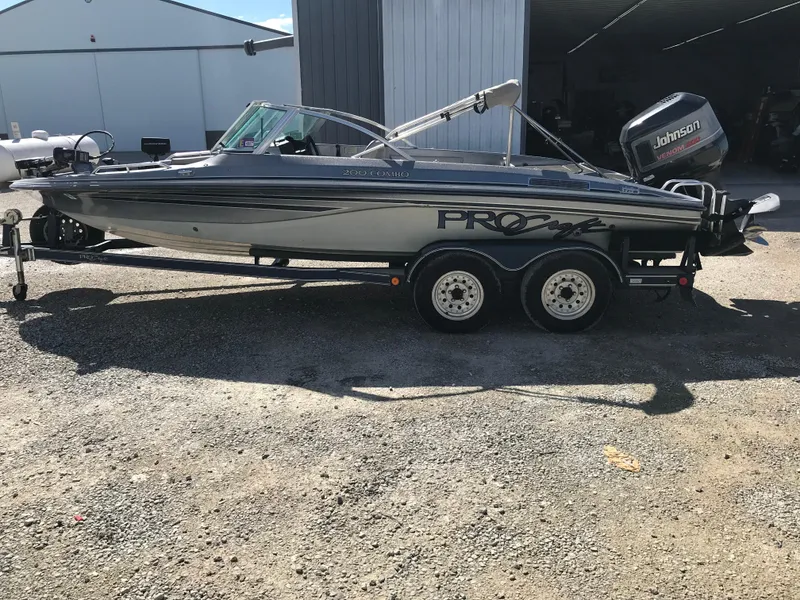 Slide: The Image of 1994 ProCraft COMBO 200 boat on trailer, parked outdoors, with Johnson outboard motor. - 1