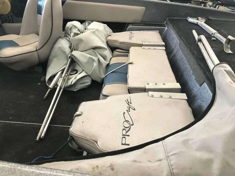 Slide: The Image of 1994 ProCraft COMBO 200 boat interior with seats, poles, and cover. - 10