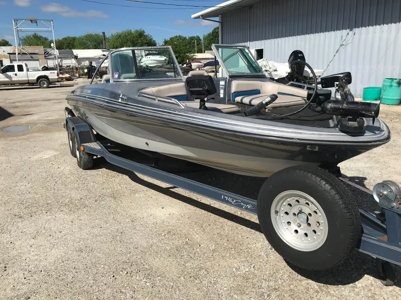 Slide: The Image of 1994 ProCraft COMBO 200 boat on trailer, parked outdoors near industrial building. - 2