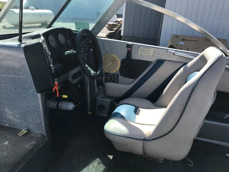 Slide: The Image of Interior of a 1994 ProCraft COMBO 200 boat, featuring steering wheel and seating. - 21