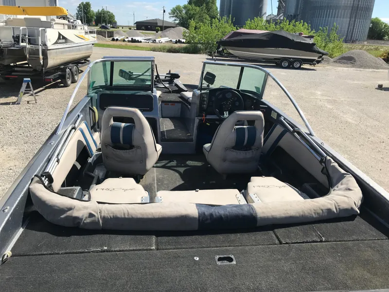 Slide: The Image of 1994 ProCraft COMBO 200 boat interior with seating and steering wheel, parked outdoors. - 34