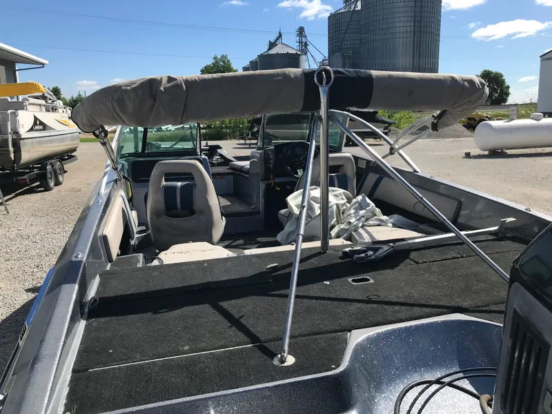 Slide: The Image of 1994 ProCraft COMBO 200 boat with canopy, parked outdoors near silos. - 35