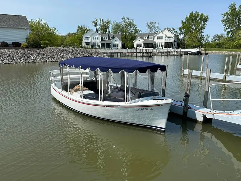 Slide: The Image of 2022 Duffy 22 Sun Cruiser docked on calm water with houses in the background. - 0