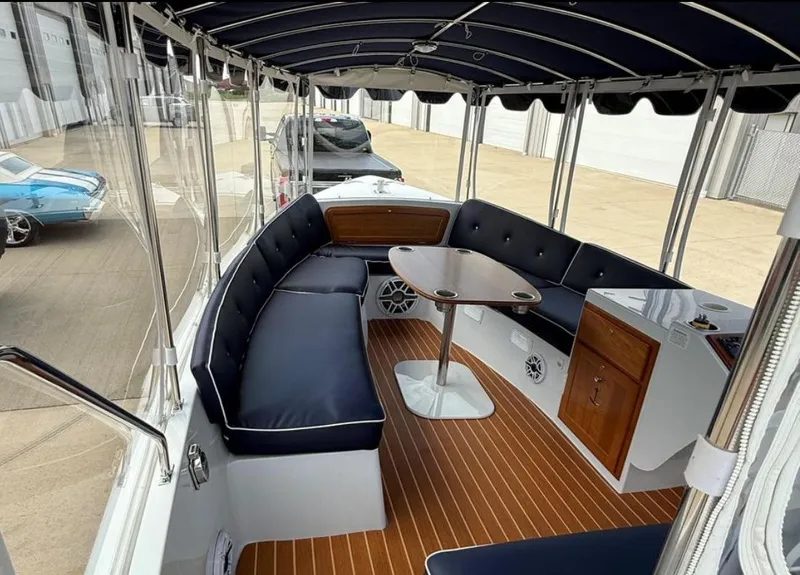 Slide: The Image of Interior of 2022 Duffy 22 Sun Cruiser with navy seating and wooden accents. - 11