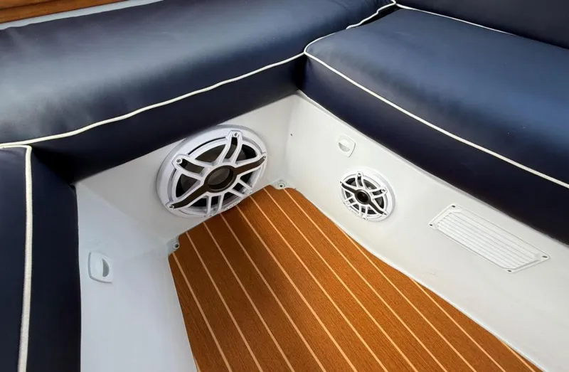 Slide: The Image of Interior of 2022 Duffy 22 Sun Cruiser with navy seating and wood flooring. - 14
