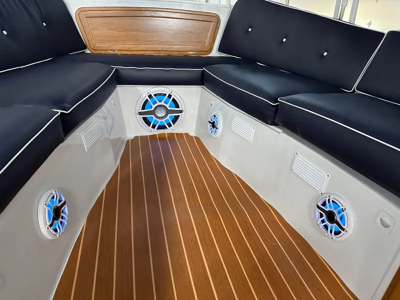 Slide: The Image of 2022 Duffy 22 Sun Cruiser interior with cushioned seating and wood-style flooring. - 16
