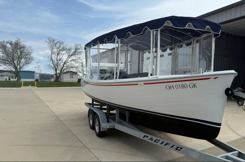 Slide: The Image of 2022 Duffy 22 Sun Cruiser boat on trailer, parked outdoors under a clear sky. - 3