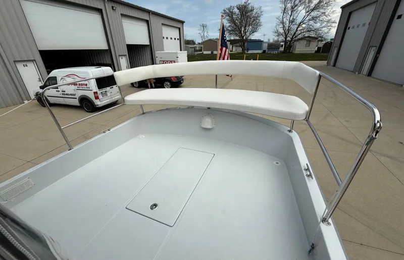 Slide: The Image of 2022 Duffy 22 Sun Cruiser boat with white seating, docked near industrial buildings. - 7