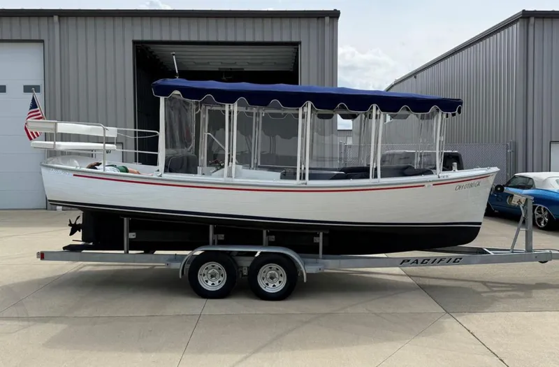 Slide: The Image of 2022 Duffy 22 Sun Cruiser boat on trailer, parked outside a metal building. - 8