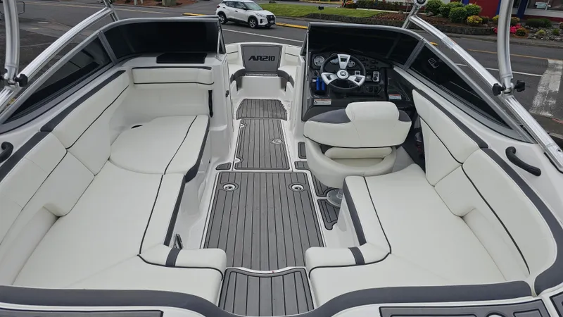 Slide: The Image of 2014 Yamaha AR210 boat interior with sleek white seating and modern dashboard. - 12
