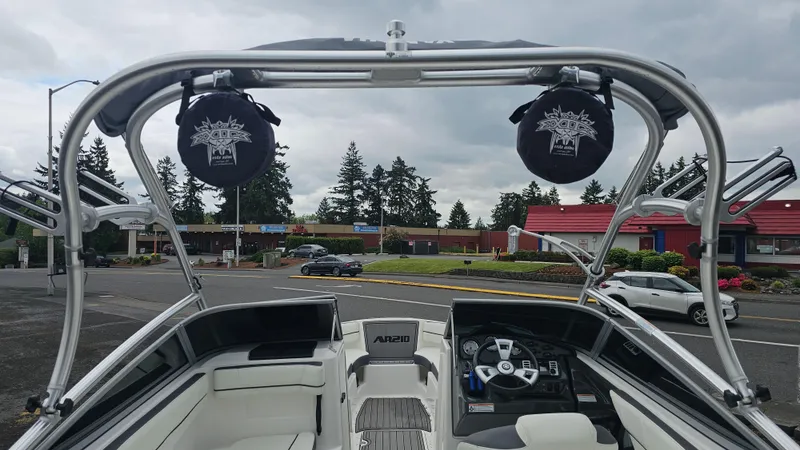 Slide: The Image of 2014 Yamaha AR210 boat interior with speakers and steering wheel, parked outdoors. - 13