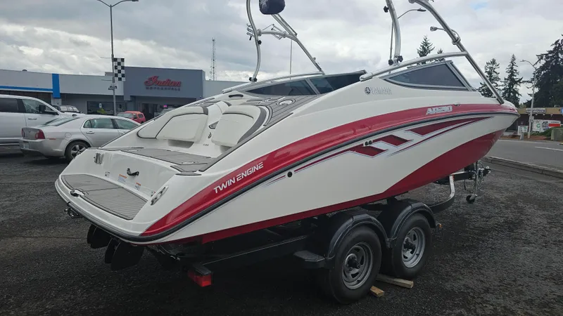 Slide: The Image of 2014 Yamaha AR210 boat with red accents on a trailer, parked outdoors. - 5