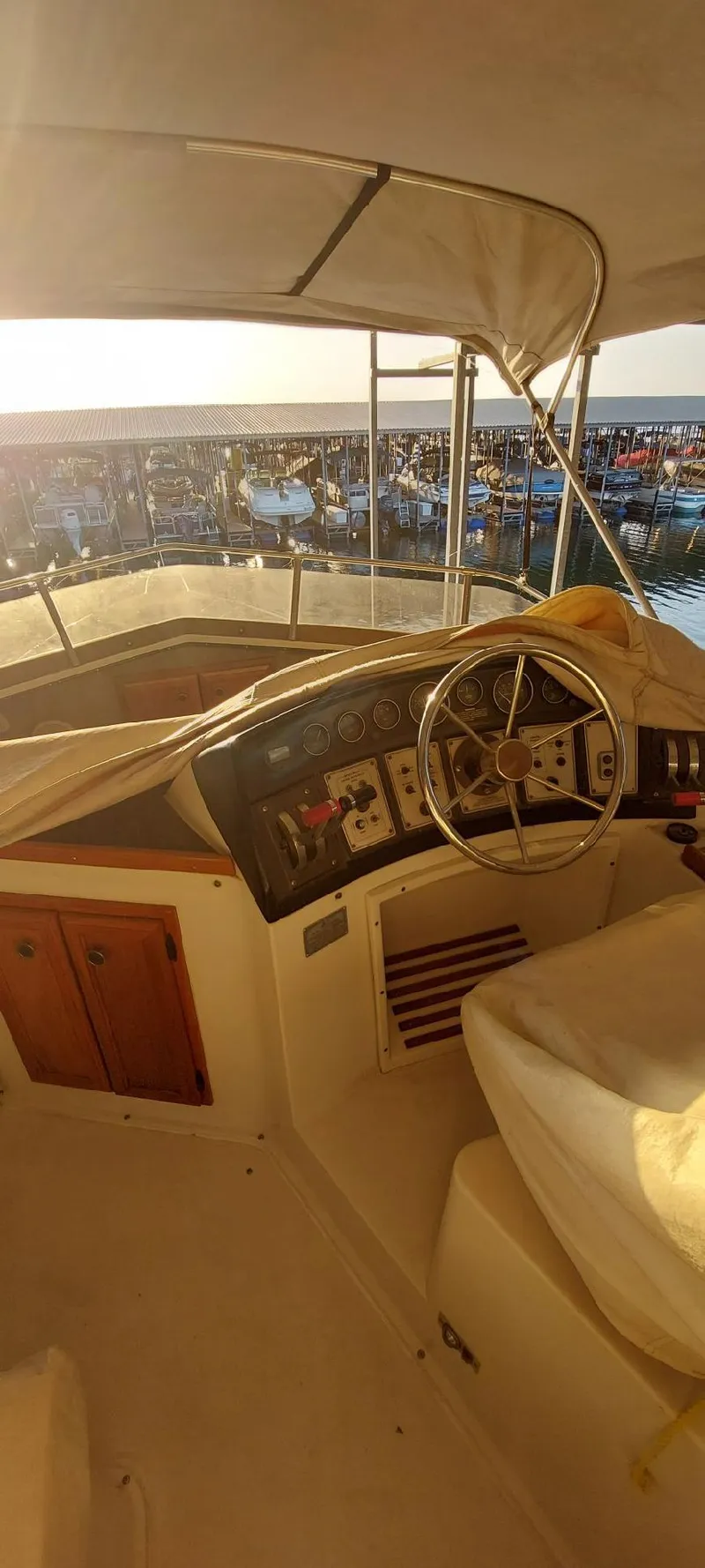 Slide: The Image of 1990 Carver 3607 Aft Cabin boat interior with steering wheel and dashboard at sunset. - 9