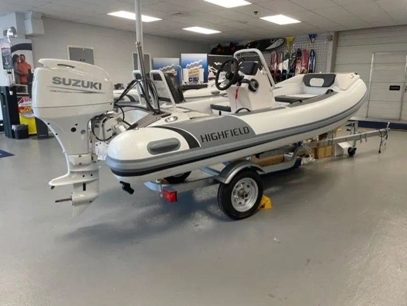 Slide: The Image of 2025 Highfield Sport 390 boat with Suzuki engine on display in showroom. - 1