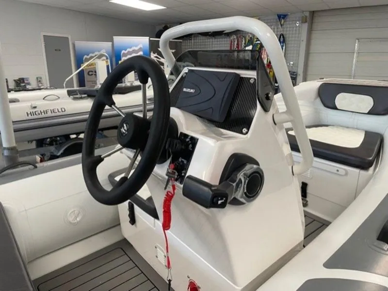 Slide: The Image of Highfield Sport 390 boat interior, featuring steering wheel and control panel, 2025 model. - 5