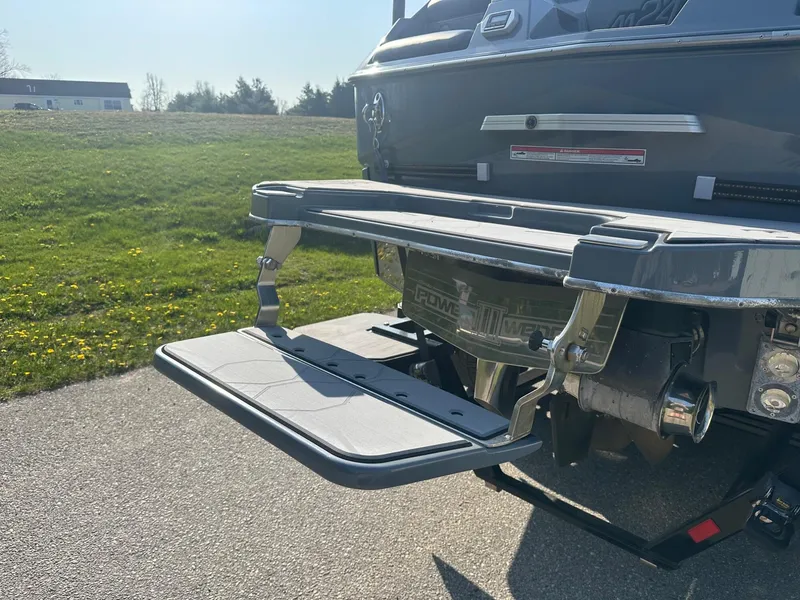 Slide: The Image of 2020 Malibu M240 boat with extended swim platform in a sunny outdoor setting. - 11