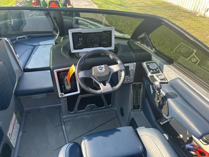 Slide: The Image of 2020 Malibu M240 boat interior with steering wheel and dashboard display. - 16