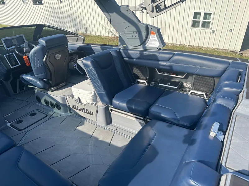 Slide: The Image of 2020 Malibu M240 boat interior with blue leather seating and modern dashboard. - 24