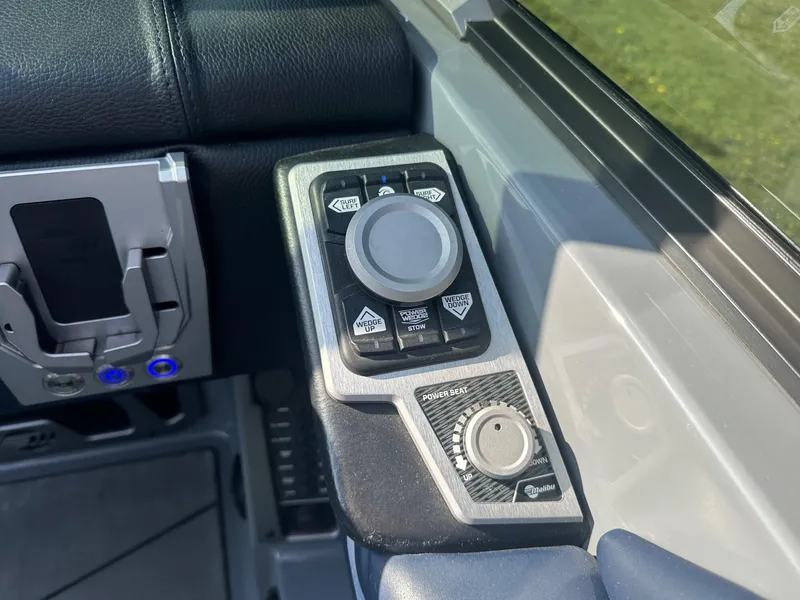 Slide: The Image of Control panel of a 2020 Malibu M240 boat with various buttons and dials. - 28