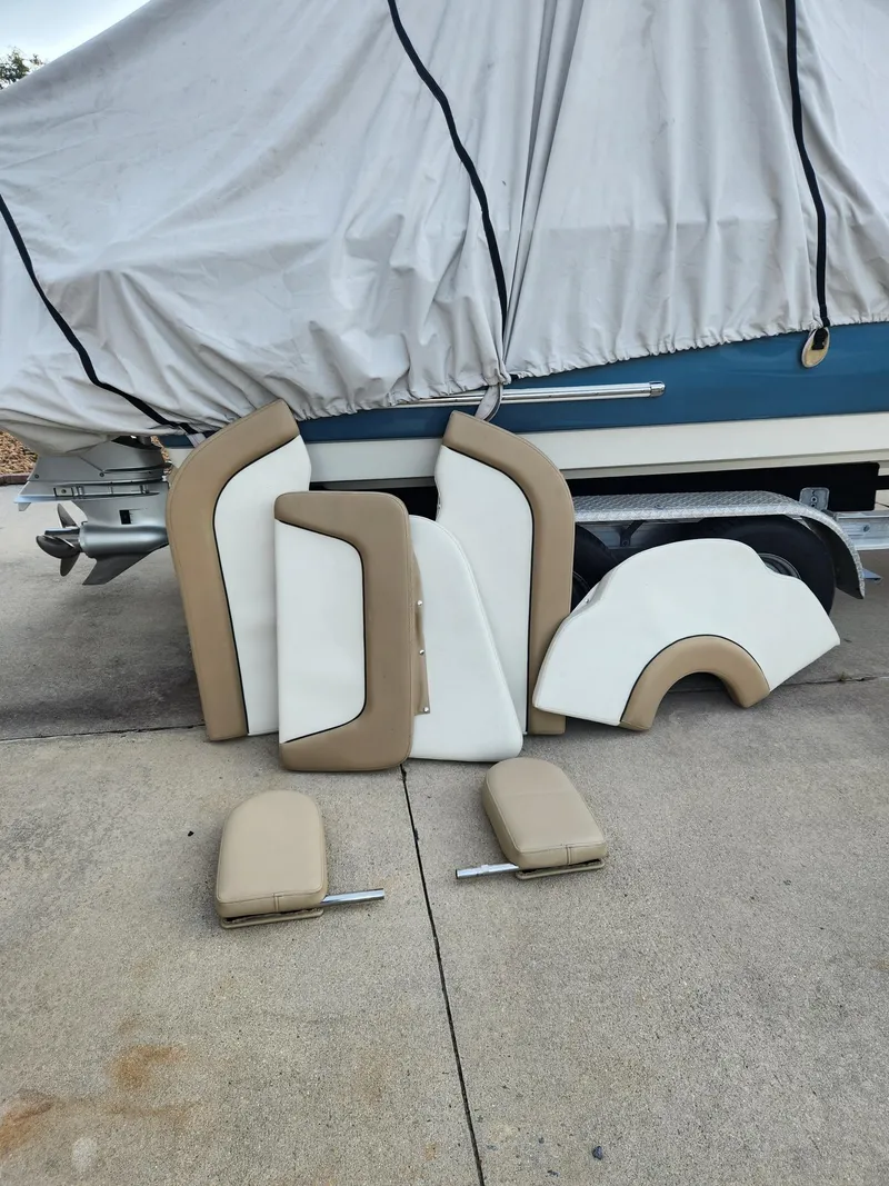Slide: The Image of Cushions for 2019 Pioneer 222 Sportfish boat, displayed on pavement near covered boat. - 8