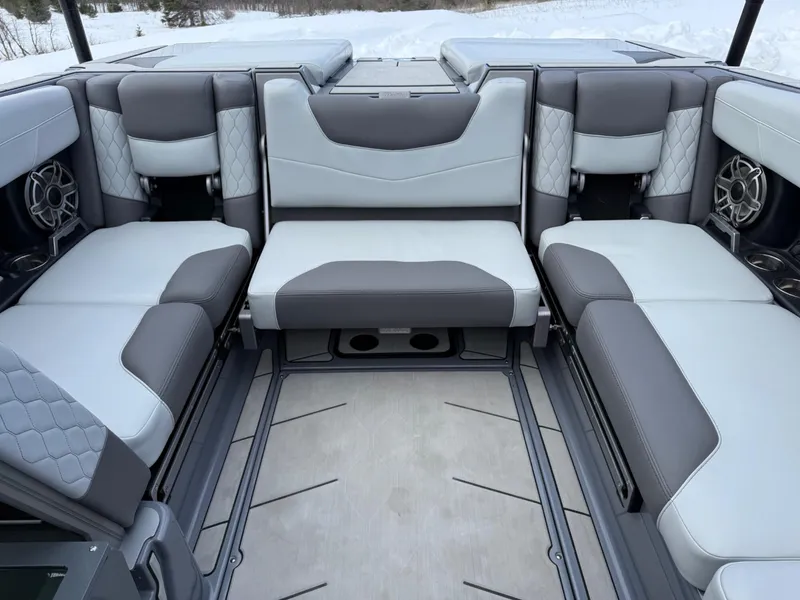 Slide: The Image of 2021 Malibu M240 boat interior with gray and white seating, featuring premium upholstery and speakers. - 13