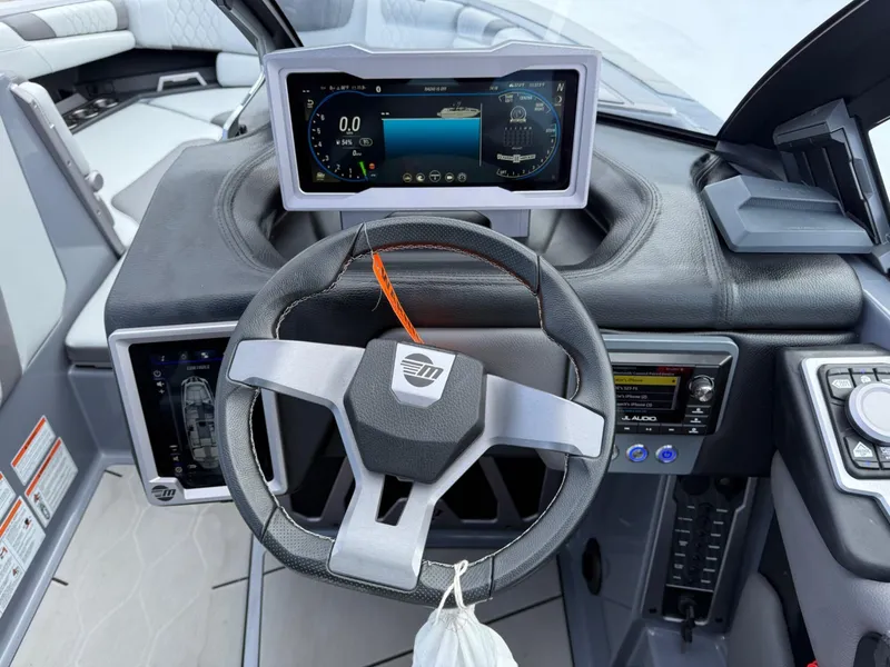 Slide: The Image of 2021 Malibu M240 boat dashboard with steering wheel and digital display. - 17