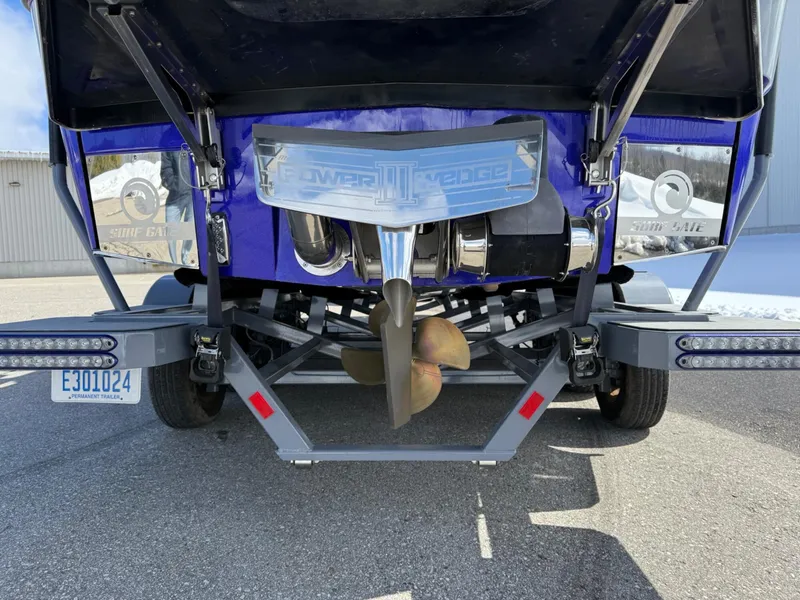 Slide: The Image of Rear view of a 2021 Malibu M240 boat with visible propeller and trailer. - 4