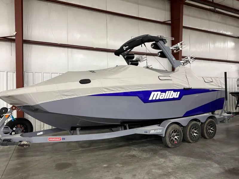 Slide: The Image of 2021 Malibu M240 boat on trailer, covered, in indoor storage facility. - 8