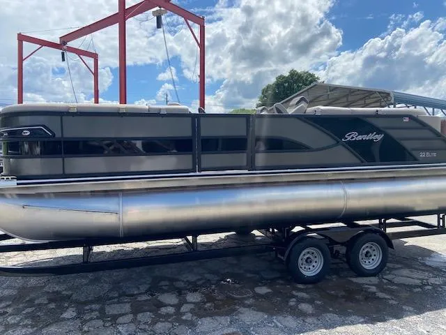 Slide: The Image of 2025 Bentley Pontoons 223 Elite Admiral on trailer under blue sky. - 2