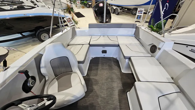 Slide: The Image of 2022 Glastron GTD 180 boat interior with seating and steering wheel, displayed at a showroom. - 8