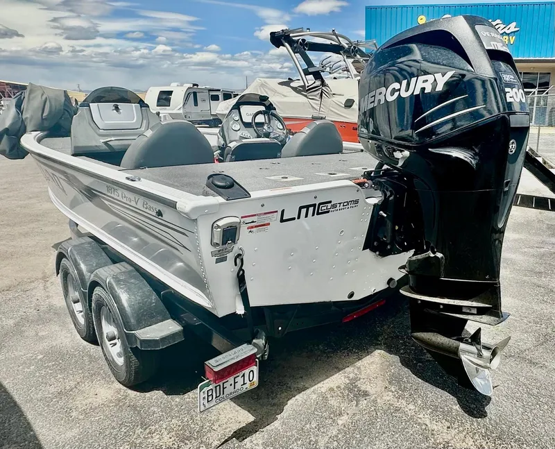 Slide: The Image of 2018 Lund 1875 Pro-V Bass boat with Mercury 200 engine, parked outdoors. - 3