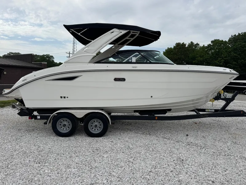 The Image of 2025 Sea Ray SDX 250 boat on a trailer, parked on gravel. - 0