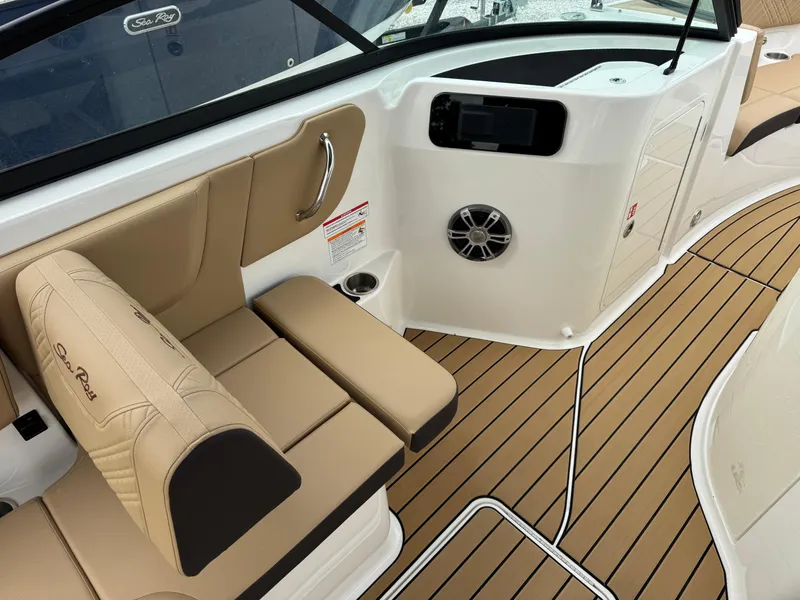 Slide: The Image of 2025 Sea Ray SDX 250 boat interior with tan seating and wood-style flooring. - 10
