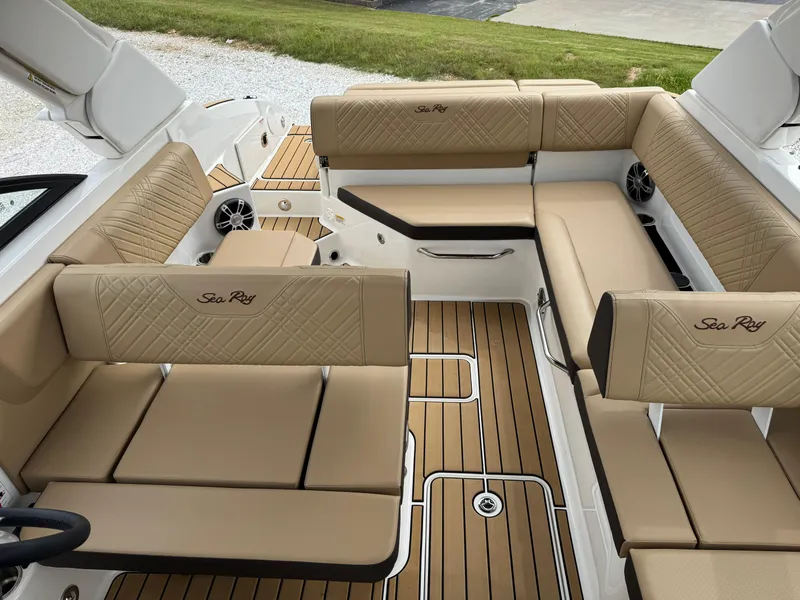 Slide: The Image of 2025 Sea Ray SDX 250 boat interior with tan seating and wood-style flooring. - 12
