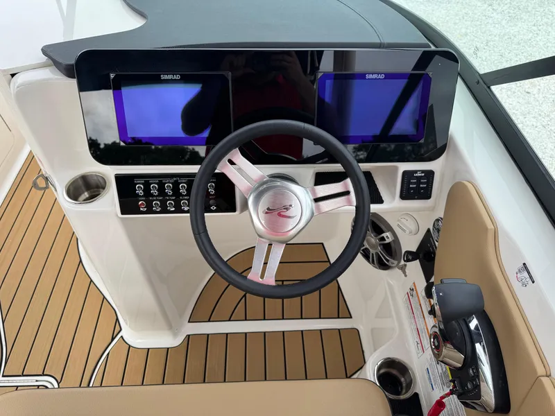 Slide: The Image of 2025 Sea Ray SDX 250 helm with dual Simrad displays and modern steering wheel. - 16